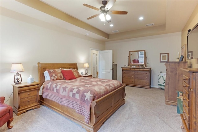 bedroom featuring recessed lighting, a raised ceiling, light colored carpet, visible vents, and a ceiling fan