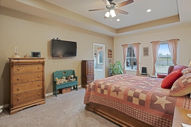 bedroom featuring recessed lighting, a raised ceiling, light carpet, and baseboards