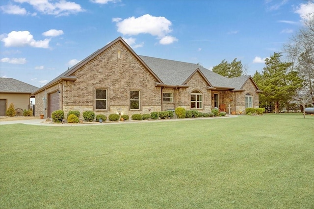 view of front of house featuring a garage, brick siding, roof with shingles, and a front yard