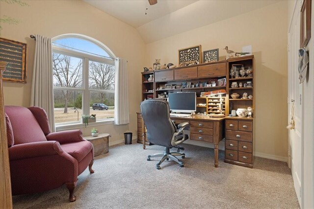 office space with lofted ceiling, ceiling fan, baseboards, and light colored carpet