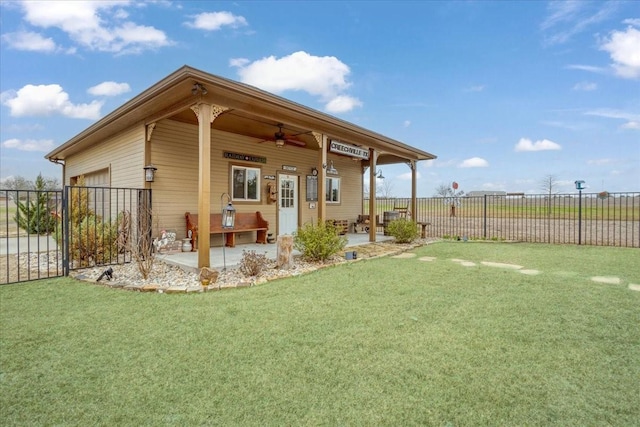 exterior space featuring a yard, a patio, an attached garage, fence, and ceiling fan