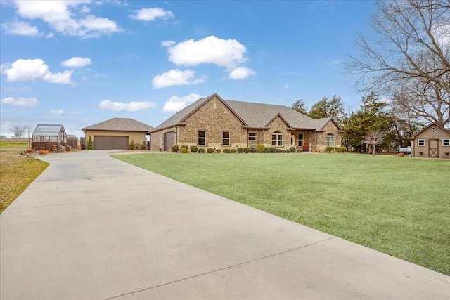 french country inspired facade featuring a front lawn and an outbuilding