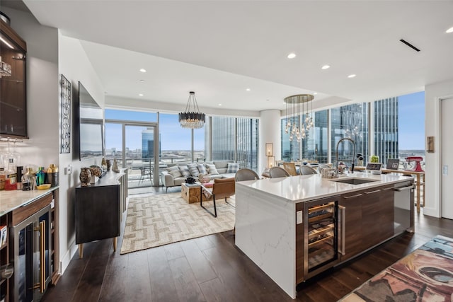 kitchen with a notable chandelier, beverage cooler, a sink, dark brown cabinets, and dark wood-style floors