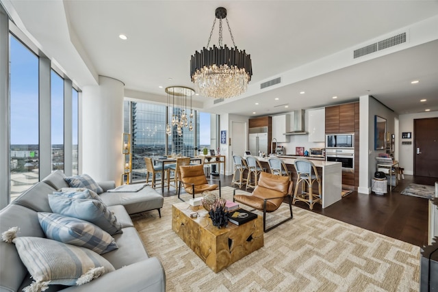 living room featuring a chandelier, wood finished floors, visible vents, and recessed lighting