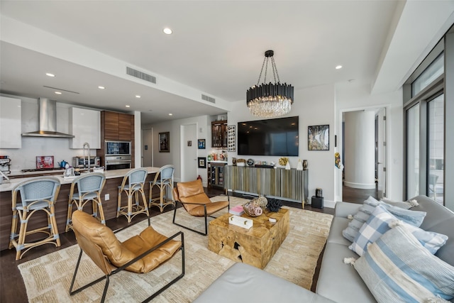 living area with light wood finished floors, visible vents, an inviting chandelier, and recessed lighting