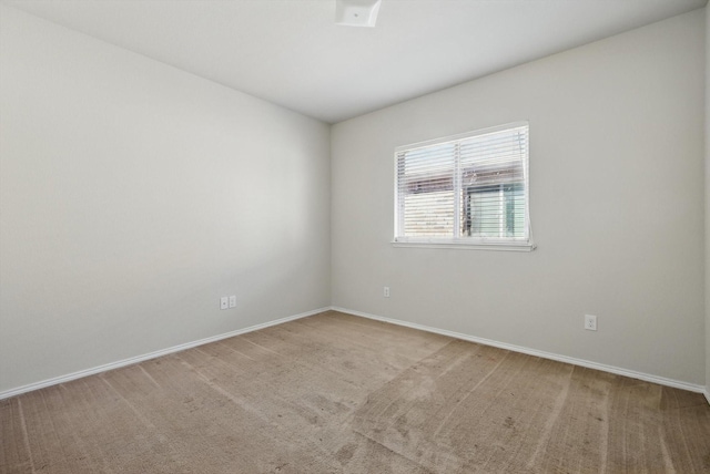 carpeted spare room featuring baseboards