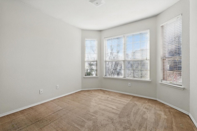 carpeted empty room with baseboards