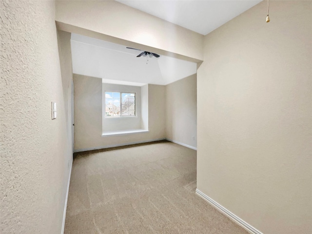 empty room featuring carpet floors, ceiling fan, baseboards, and a textured wall