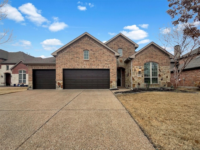 view of front of property with a garage, brick siding, concrete driveway, stone siding, and a front yard