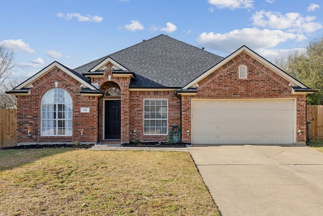 view of front of house featuring concrete driveway, a shingled roof, a front yard, and fence