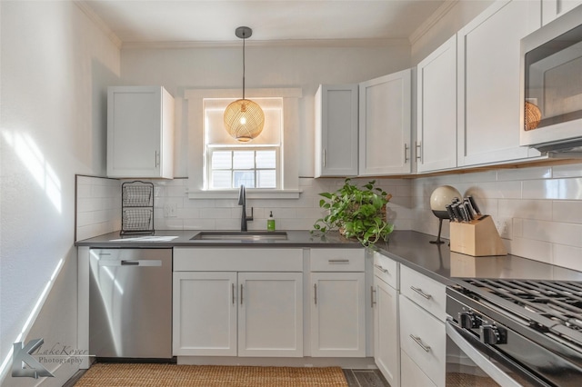 kitchen featuring tasteful backsplash, crown molding, appliances with stainless steel finishes, and a sink