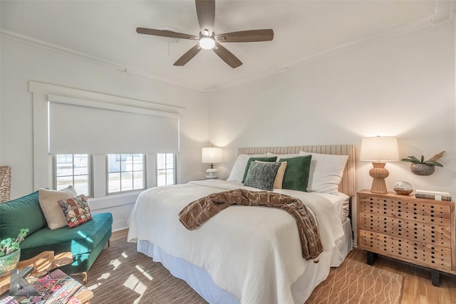 bedroom featuring crown molding, ceiling fan, and wood finished floors