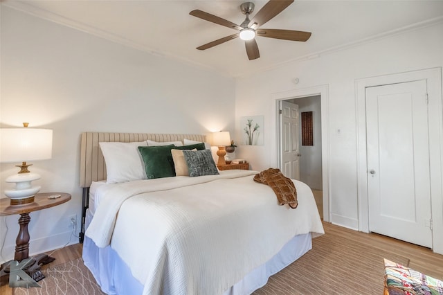 bedroom featuring ceiling fan, ornamental molding, wood finished floors, and baseboards