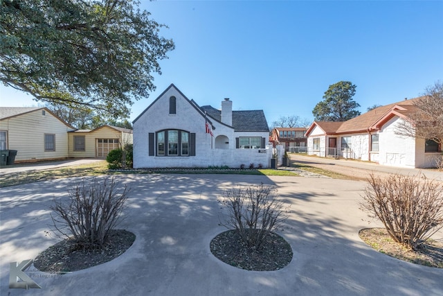 french country style house with a chimney, fence, and stucco siding