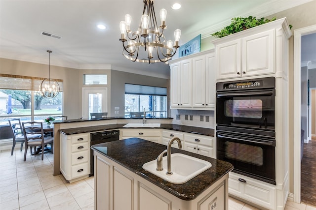 kitchen featuring a notable chandelier, a peninsula, a sink, visible vents, and black appliances