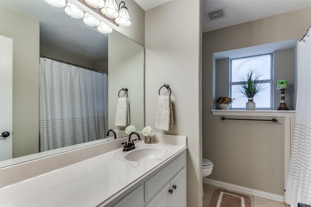 bathroom with toilet, vanity, baseboards, visible vents, and tile patterned floors