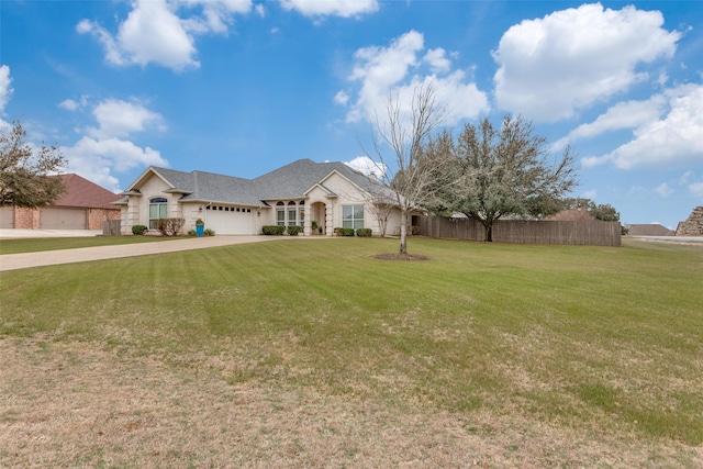 french country style house featuring a garage, concrete driveway, fence, and a front lawn