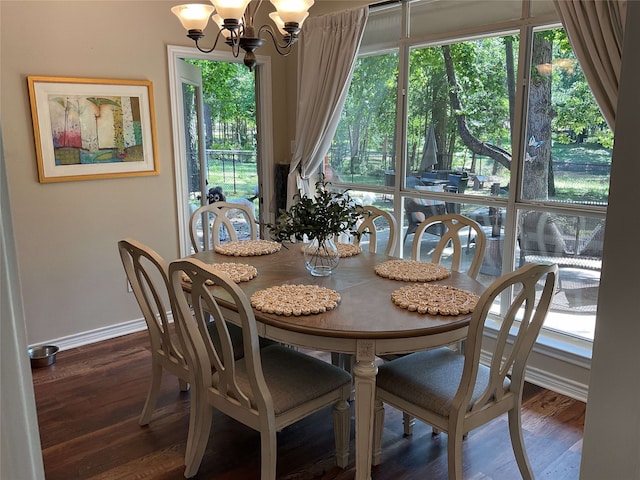 dining space with baseboards, a chandelier, and wood finished floors