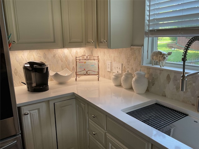 kitchen with light countertops, tasteful backsplash, and stainless steel fridge