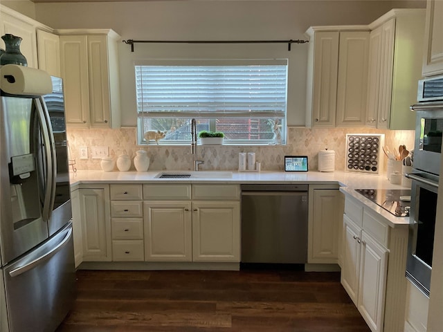 kitchen with dark wood finished floors, appliances with stainless steel finishes, a sink, and white cabinetry