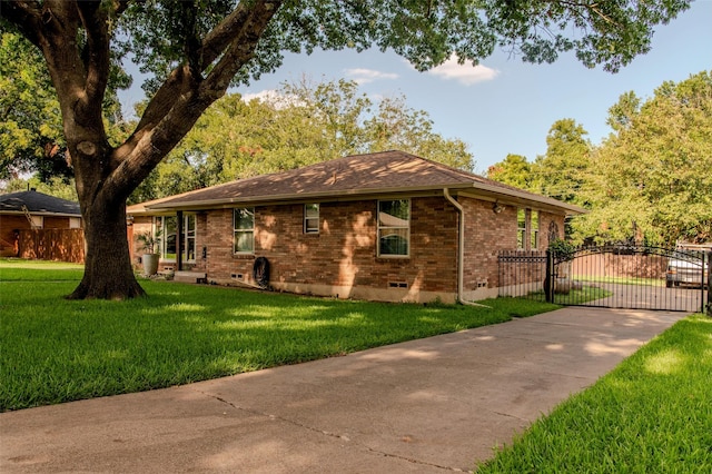 view of property exterior featuring a gate, brick siding, a lawn, and fence