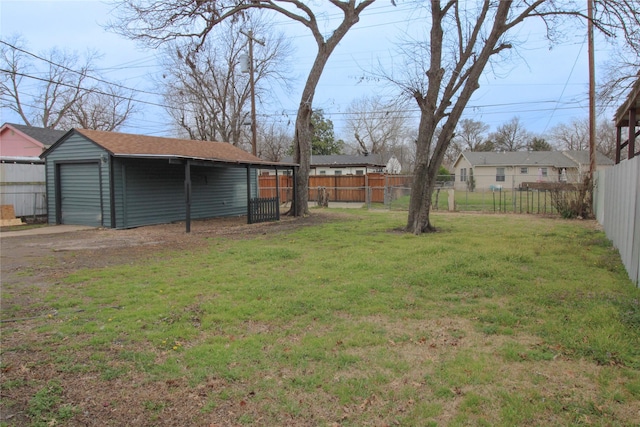 view of yard featuring a garage, fence private yard, and an outdoor structure