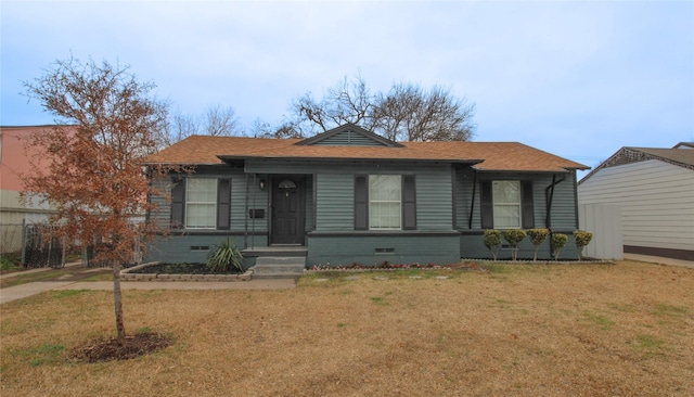 bungalow with crawl space, a shingled roof, and a front lawn