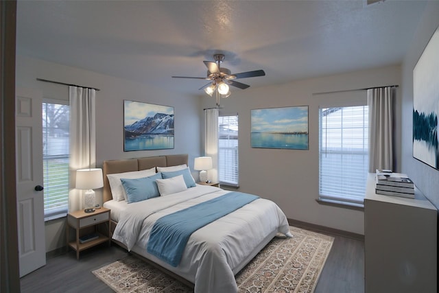 bedroom with ceiling fan, baseboards, and wood finished floors