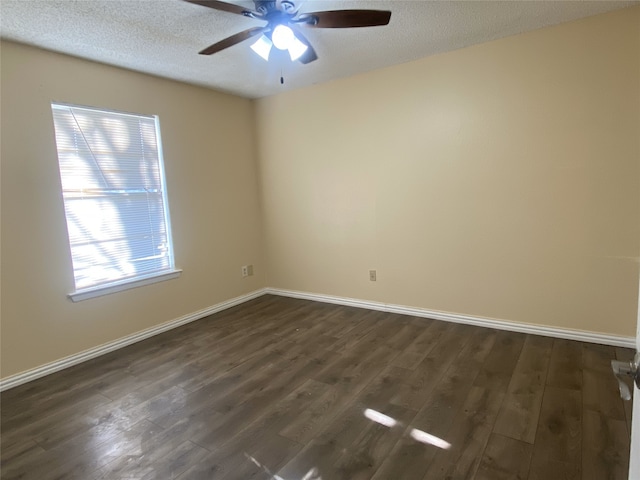 spare room featuring a ceiling fan, a textured ceiling, baseboards, and dark wood-type flooring