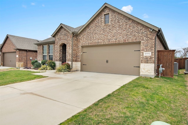 view of front facade featuring brick siding, a front lawn, an attached garage, and central air condition unit