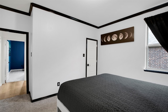 bedroom with light carpet, ornamental molding, and baseboards