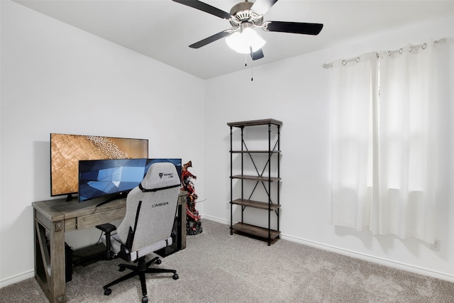 carpeted home office featuring a ceiling fan and baseboards