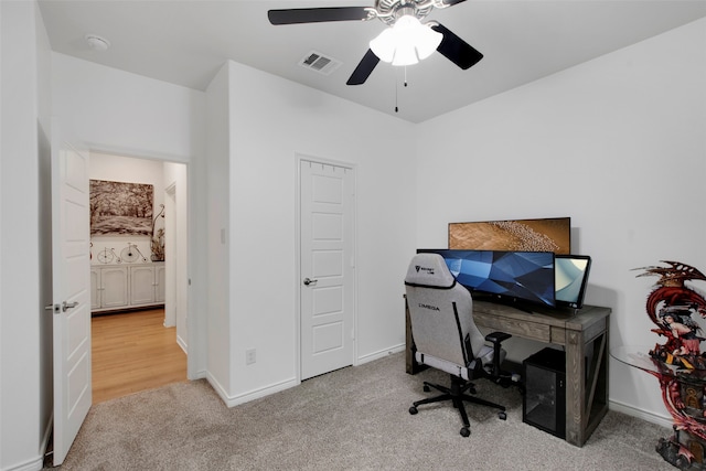 office with a ceiling fan, carpet, visible vents, and baseboards