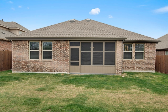 back of property featuring a shingled roof, a fenced backyard, and a lawn