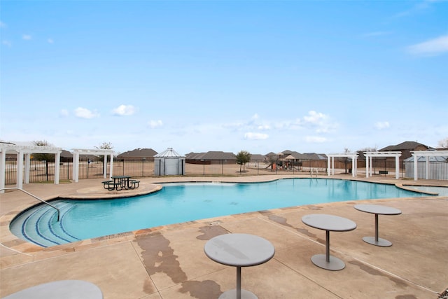 pool with a patio area, fence, and a pergola