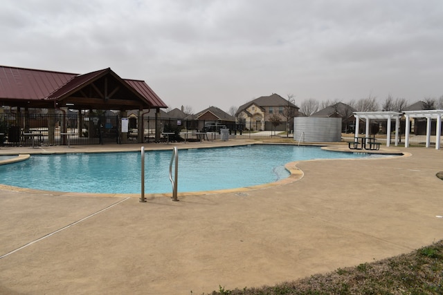 pool with a patio area, fence, and a pergola