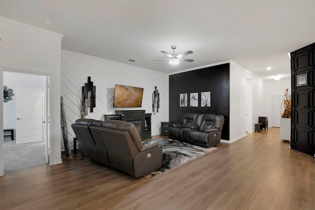 living room featuring a ceiling fan, crown molding, and wood finished floors