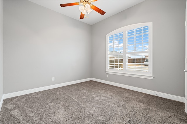 carpeted empty room featuring a ceiling fan and baseboards