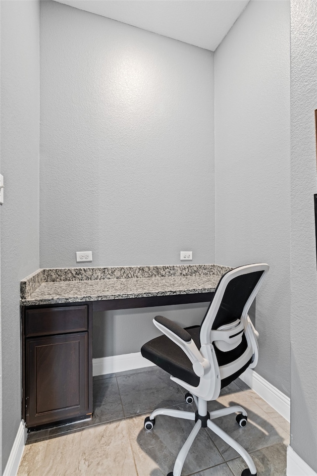 home office with baseboards and built in desk