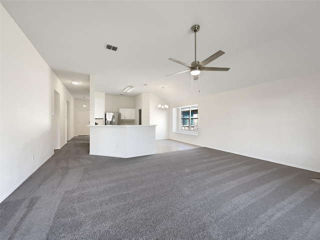 unfurnished living room featuring vaulted ceiling, visible vents, dark colored carpet, and a ceiling fan