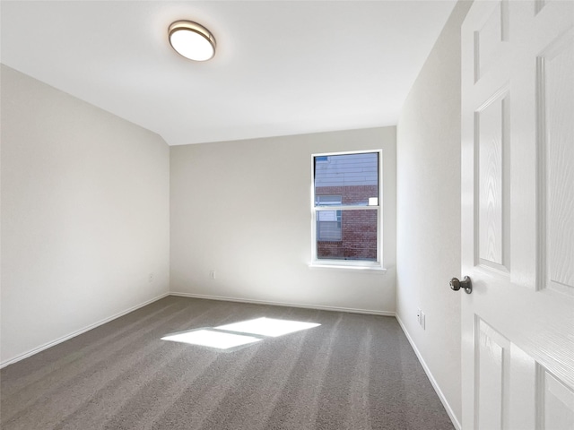 carpeted spare room featuring baseboards