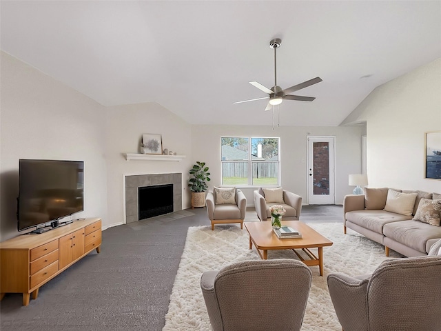 carpeted living area with vaulted ceiling, ceiling fan, and a fireplace