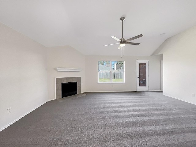 unfurnished living room with vaulted ceiling, ceiling fan, a tile fireplace, and baseboards