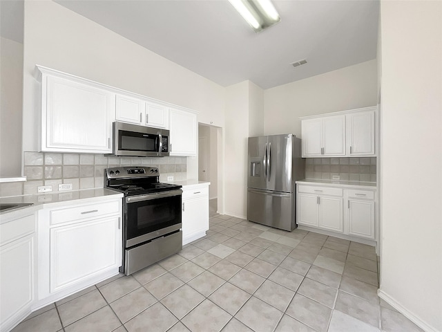 kitchen with stainless steel appliances, light countertops, white cabinets, and visible vents