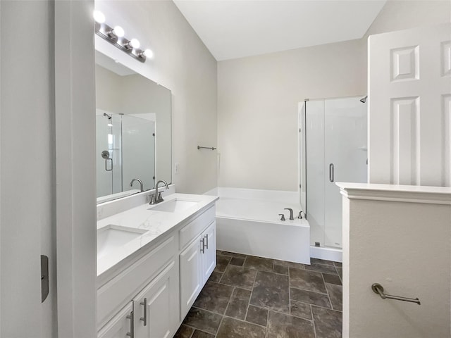 bathroom featuring a bath, a stall shower, double vanity, and a sink