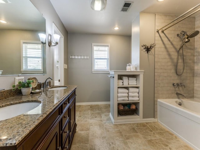 full bathroom featuring double vanity, visible vents, baseboards, and a sink