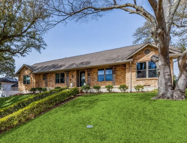 single story home with crawl space, brick siding, roof with shingles, and a front yard