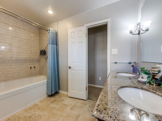 bathroom with double vanity, shower / bathtub combination with curtain, baseboards, and a sink