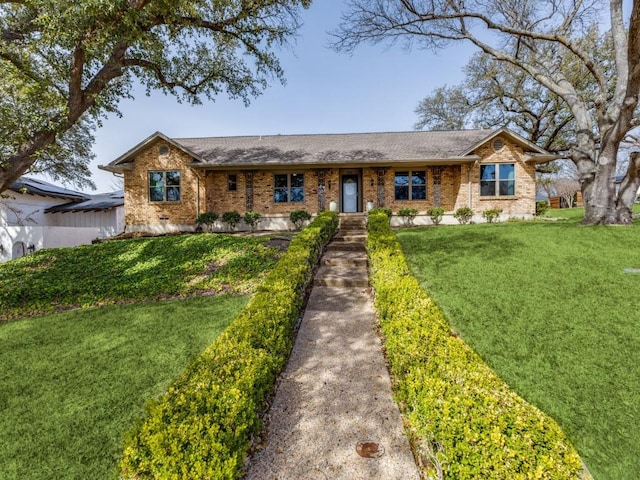 single story home featuring a front yard and brick siding