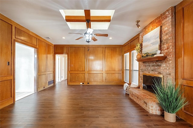 unfurnished living room featuring dark wood-style floors, visible vents, a fireplace, and a decorative wall